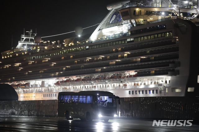  [요코하마=AP/뉴시스]17일 일본 요코하마항에 정박 중인 유람선 다이아몬드 프린세스호에 격리조치 됐던 미국인들을 태운 버스가 이동하고 있다. 이들은 도쿄 하네다공항에서 전세기를 통해 미국으로 돌아가 캘리포니아 트래비스 공군기지와 텍사스 랙랜드 공군기지에서 14일간 격리된다. 2020.02.17. 