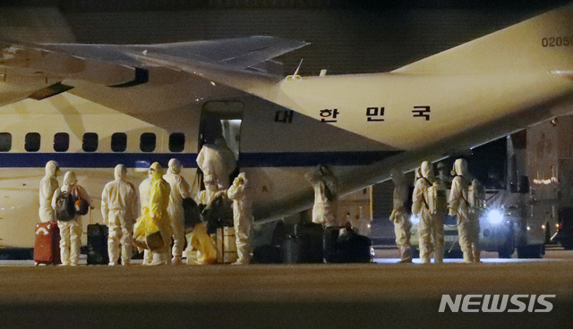 [서울=뉴시스] 고범준 기자 = 방역 관계자들이 19일 오전 서울 강서구 김포국제공항에 도착한 신종 코로나 바이러스 감염증(코로나19)발병으로 크루즈선 '다이아몬드 프린세스'호에 격리되어 있던 교민들이 탑승한 대통령 전용기(공군3호기)에서 수하물을 내리고 있다. 2020.02.19. bjko@newsis.com