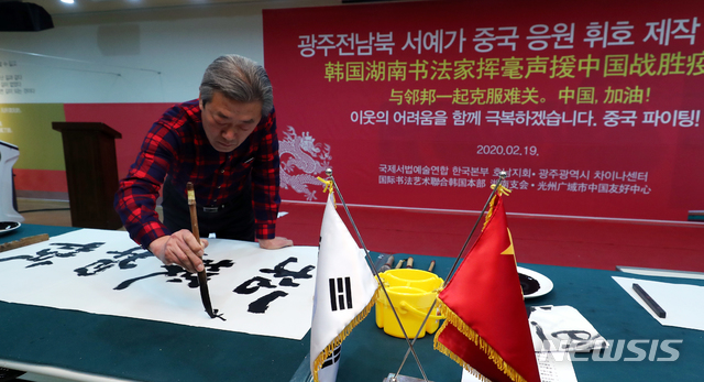 [광주=뉴시스] 류형근 기자 = 19일 오전 광주차이나센터에서 서예가 오명섭씨가 '송무백열(松茂柏悅)' 휘호를 쓰고 있다. '소나무가 무성하면 잣나무가 기뻐한다'는 뜻으로, 중국이 코로나19 위기를 극복하기를 바라는 마음을 담았다. (사진=광주전남사진기자회 제공) 2020.02.19 photo@newsis.com