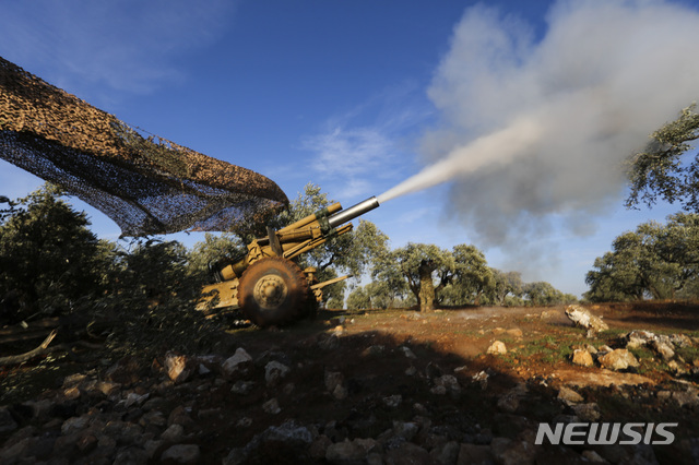 [네이랍=AP/뉴시스]터키의 지원을 받는 반군들이 20일(현지시간) 시리아 이들리브주 네이랍 마을 근처에서 시리아 정부군 진지를 향해 곡사포를 발사하고 있다. 터키 국방부는 시리아 정부군의 공습으로 터키 병사 2명이 숨지고 5명이 부상했다고 밝혔다. 앞서 터키는 러시아와 이들리브주와 알레포주 등지에서 긴장 완화를 위해 협상을 벌였으나 합의를 보지 못해 에르도안 터키 대통령이 군사작전을 예고한 바 있다. 2020.02.21.