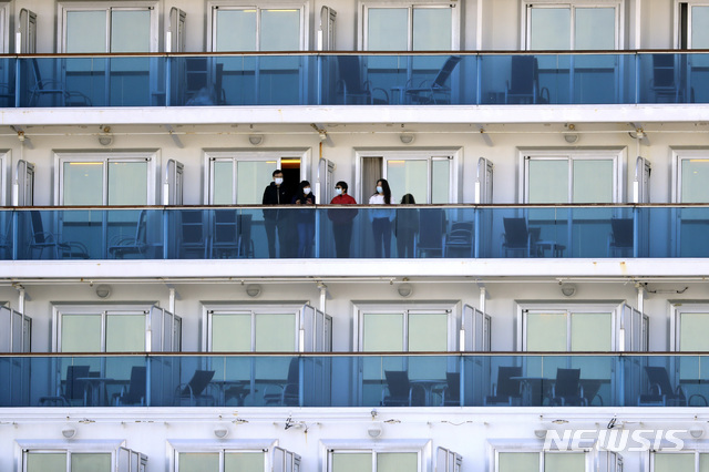 [요코하마=AP/뉴시스]지난달 21일 일본 요코하마항에 격리, 정박 중인 유람선 다이아몬드 프린세스호 발코니에서 승객들이 얘기를 나누고 있다. 2020.02.21. 