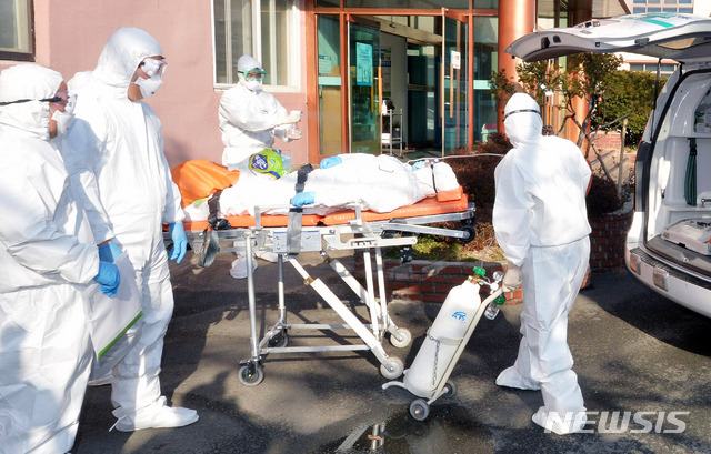 [청도=뉴시스] 이무열 기자 = 신종 코로나바이러스 감염증(코로나19)으로 국내 첫 사망자가 발생한 곳으로 알려진 21일 오후 경북 청도군 대남병원에서 질병관리본부 관계자들이 코로나19 의심 환자를 이송하고 있다. 2020.02.21.lmy@newsis.com