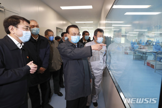 [베이징=AP/뉴시스]리커창 중국 총리가 21일 중국 베이징의 한 의료방호물자 생산업체를 방문해 마스크 생산 현장을 둘러보고 있다. 리커창 총리는 마스크의 필요성에 대해 역설하면서 "분초를 다투어 생산량을 늘려야 한다"라고 강조했다. 2020.02.22. 