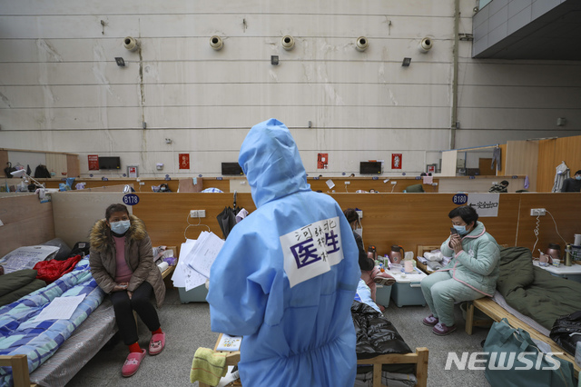 [우한=AP/뉴시스]21일(현지시간) 중국 후베이성 우한의 타즈후 체육센터에 마련된 임시 병원에서 한 의료 종사자가 신종 코로나바이러스 감염증(코로나19) 환자들을 진료하고 있다.  2020.02.22.