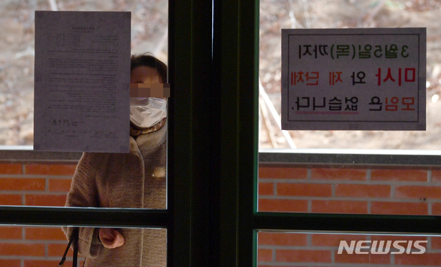 [광주=뉴시스] 류형근 기자 = 신종 코로나 바이러스 감염증(코로나19) 확산으로 인해 미사와 예배 등이 중단된 가운데 23일 오전 광주 남구 한 성당에서 신자가 마스크를 착용하고 미사 중단 안내 문구를 보고 있다. 2020.02.23. hgryu77@newsis.com