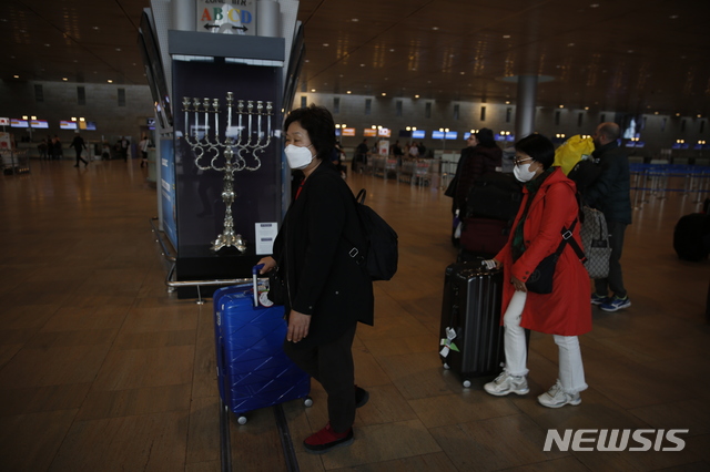 [텔아비브=AP/뉴시스] 23일(현지시간) 이스라엘 텔아비브의 벤구리온 국제공앙에서 여행객들이 마스크를 쓴 채 이동하고 있다. 이스라엘 외교부는 23일(현지시간) 성명을 발표하고 "한국에 대한 여행을 심각하게 재고할 것을 권고한다"고 밝혔다. 2020.2.24.