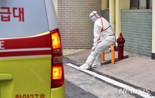 [대구=뉴시스] 이무열 기자 = 신종 코로나바이러스 감염증(코로나19) 확진자가 급증하고 있는 지난달 24일 오후 대구 중구 계명대학교 대구동산병원에서 한 방역 관계자가 시설물에 앉아 잠시 휴식을 취하고 있다. 3일 질병관리본부는 코로나19 관련 사망자가 3명 더 늘어 총 31명이라고 밝혔다. 2020.02.24. lmy@newsis.com