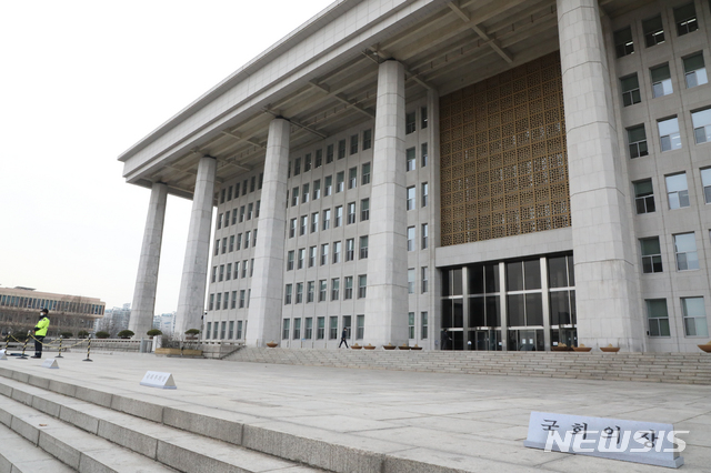[서울=뉴시스]김명원 기자 = 코로나19 확진자가 국회 토론회에 참가한 것으로 뒤늦게 확인된 가운데 24일 서울 여의도 국회 본청 2층 정현관 및 남문, 동문이 폐문 됐다. 본청앞은 주차된 차량없이 텅비어있고 근무중인 경찰만이 지키고 있다. 2020.02.24. kmx1105@newsis.com