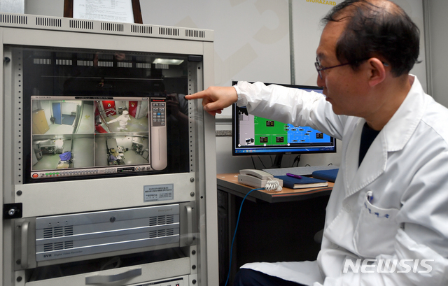 [광주=뉴시스] 류형근 기자 = 25일 오후 광주 서구 광주보건환경연구원에서 연구원이 의뢰 들어온 신종 코로나 바이러스 감염증(코로나19) 검체를 검사하고 있는 가운데 CCTV를 통해 확인하고 있다. 2020.02.25. hgryu77@newsis.com