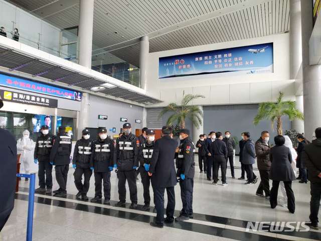 [서울=뉴시스] 중국 산둥성 웨이하이국제공항에서 25일 방역요원들이 제주항공편으로 입국한 승객들을 버스에 태우고 있다. (사진=독자 제공) 2020.02.25.  