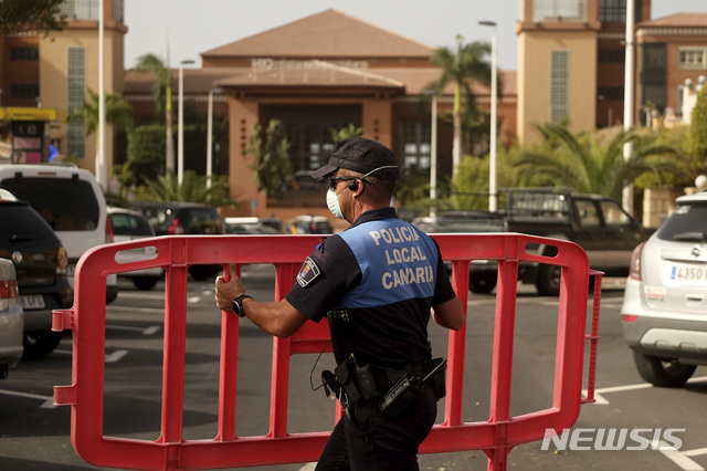 [테네리페=AP/뉴시스]25일(현지시간) 스페인령 카나리아제도 테네리페에 위치한 호텔 'H10 코스타 아데헤 팔라세'에서 경찰이 건물 진입을 차단하고 있다. 이 호텔은 이탈리아인 투숙객이 신종 코로나바이러스 감염증(코로나19) 확진 판정을 받은 뒤 폐쇄됐다. 2020.2.26. 