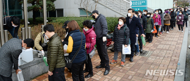 [전주=뉴시스] 김얼 기자= 전북 전주시가 코로나19의 확산을 방지하고자 일제소독 주간으로 지정하고 실시한 26일 완산구 서신동 주민센터에서 무료로 살균제를 배포하자 많은 시민이 몰려 일대가 발 디딜 틈 없이 북적이고 있다. 2020.02.26.pmkeul@newsis.com