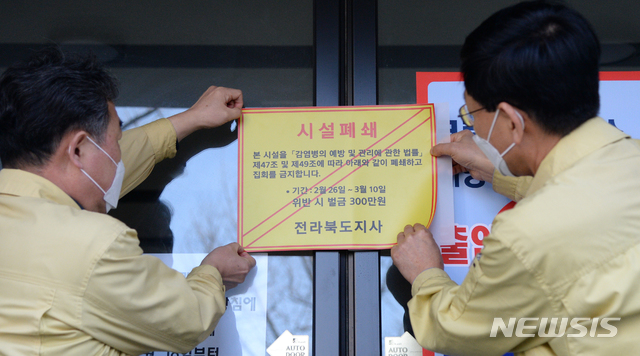 [전주=뉴시스] 김얼 기자= 26일 전북 전주시 신천지 하늘문화센터에서 전라북도 관계자들이 '감염병 예방 및 관리에 관한 법률'의 행정명령을 집행해 시설을 폐쇄하고 스티커를 붙이고 있다. 2020.02.26.pmkeul@newsis.com