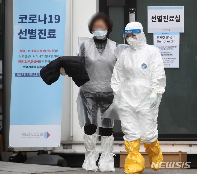 [서울=뉴시스] 조수정 기자 = 26일 오전 서울 중구 국립중앙의료원 신종 코로나 바이러스 감염증(코로나19) 선별진료소에서 의료진이 의심증상자의 선별진료를 마친 뒤 비닐을 입혀 이동시키고 있다. 26일 오전 코로나19 확진환자는 1100명을 넘어섰고 검사 진행중인 의심환자는 1만6734명에 달한다. 사망자는 12명이다. 2020.02.26. chocrystal@newsis.com
