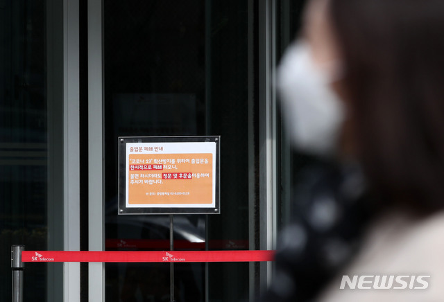 [서울=뉴시스]박미소 기자 = SK텔레콤 직원이 신종코로나바이러스감염증(코로나19) 1차 검사에서 양성판정을 받은 26일 오후 서울 중구 SK텔레콤 본사 T타워 정문에 출입문 폐쇄 안내문이 붙어있다. 2020.02.26. misocamera@newsis.com