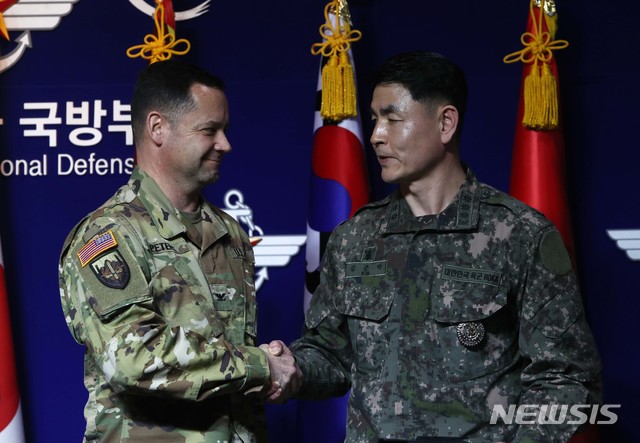 [서울=뉴시스]사진공동취재단 = 합참 공보실장 김준락 대령(오른쪽)이 27일 오전 서울 용산구 국방부에서 코로나19 확산으로 인한 한미연합군사훈련 연기에 대한 브리핑을 마치고 한미연합사 공보실장 피터스 대령과 악수를 하고 있다. 2020.02.27.&nbsp; photo@newsis.com