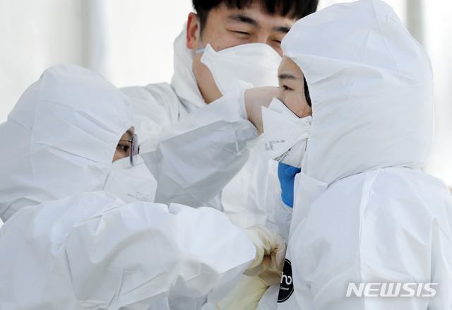 [고양=뉴시스] 최동준 기자 = 의료진들이 27일 경기 고양시 주교동 내 공용주차장에 마련된 고양 안심 카 선별진료소에서 보호복과 보호 장구 착용을 서로 도와주고 있다. 2020.02.27. photocdj@newsis.com