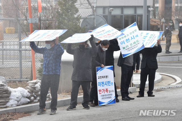 [이천=뉴시스] 김종택 기자 = 경기 이천시민들이 27일 오전 국방어학원 앞에서 2주간의 격리 생활을 마치고 퇴소하는 우한교민들을 환송하기 앞서 방역차량이 소독약을 뿌리며 지나가자 피켓으로 막고 있다. 2020.02.27. semail3778@naver.com