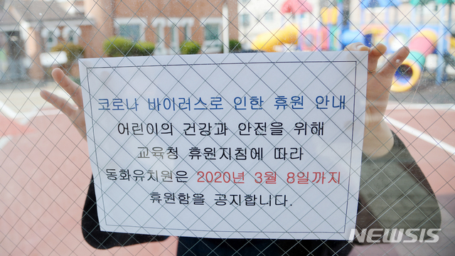 [전주=뉴시스] 김얼 기자= 코로나19의 감염 확산을 미연에 방지하기 위해 전국의 어린이집과 유치원이 휴원한 27일 전북 전주시 덕진구 동화유치원에서 교사가 휴원 안내문을 붙이고 있다. 2020.02.27.pmkeul@newsis.com