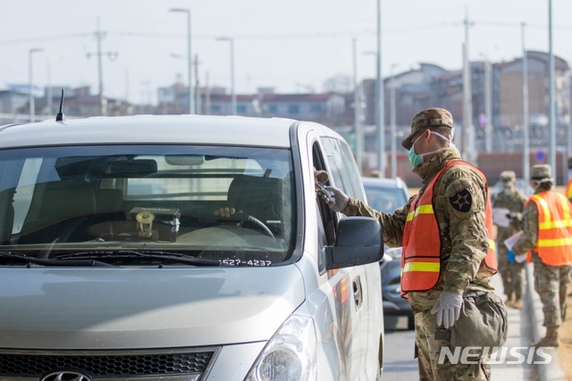 [평택=뉴시스] 주한미군 첫 코로나19 확진자(칠곡 주둔)가 발생한 가운데 미군 병사가 27일 오후 경기 평택시 주한 미군기지인 캠프 험프리 방문객들의 발열 확인을 하고 있다. (사진=주한미군 제공) 2020.02.27.photo@newsis.com
