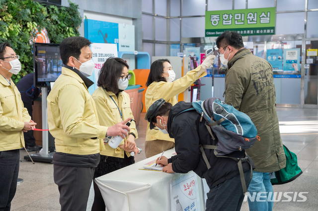 [서울=뉴시스]김근현 기자 = 양천구청을 방문한 구민들이 28일 출입구에서 신종 코로나바이러스 감염증(코로나19) 확산 방지를 위한 체온 측정을 한 뒤 방명록을 작성하고 있다. (사진=양천구 제공) 2020.02.28.photo@newsis.com