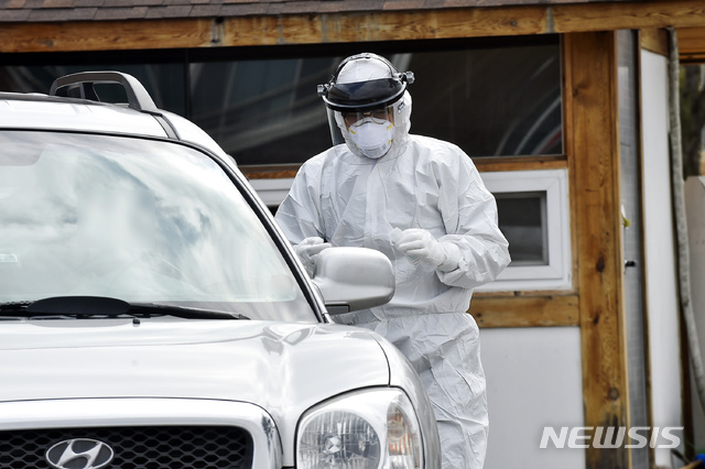 [원주=뉴시스] 김경목 기자 = 1일 강원 원주시에 신종 코로나 바이러스 감염증(코로나19) 신규 확진 환자가 3명 발생한 가운데 의료진이 원주시 태장2동 태장초등학교 인근 신천지 예수교회 예배당 주차장에서 신천지 교회 교인을 상대로 검체를 채취하고 있다. 2020.03.01. (사진=원주시청 제공) photo＠newsis.com
