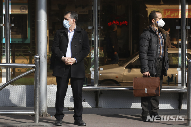 [테헤란(이란)=AP/뉴시스]이란 수도 테헤란의 한 버스 정류장에서 1일 마스크를 쓴 시민들이 버스를 기다리고 있다. 알리 하메네이 최고지도자에게 자문을 해주는 국정조정위원회 위원인 모함마드 미르모함마디(71)가 2일 코로나19로 사망했다고 이란 국영 라이도가 보도했다. 2020.3.2