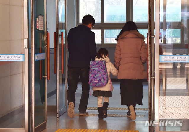 [수원=뉴시스] 김종택 기자 = 신종 코로나바이러스 감염증(코로나19) 확산에 따른 개학 연기로 긴급돌봄교실이 운영에 들어간 2일 오전 경기 수원시 한 초등학교 에서 학생들이 부모 손을 잡고 등교하고 있다.정부는 '코로나19' 확산 우려로 개학을 연기하는 대신 긴급돌봄을 기존 일과 시간에 맞춰 오전 9시부터 오후 5시까지 운영하기로 했다. 2020.03.02.semail3778@naver.com