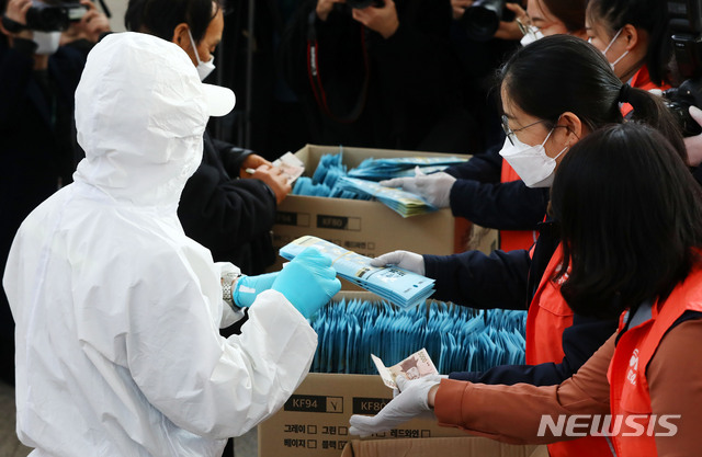 [서울=뉴시스]홍효식 기자 = 방역복을 입은 한 시민이 2일 오후 서울역 내 중소기업명품 마루매장 브랜드K 코너 앞에서 구입하고 있다. 2020.03.02. yesphoto@newsis.com