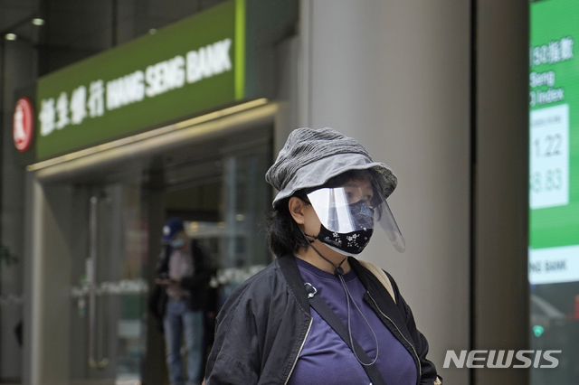 [홍콩=AP/뉴시스]3일(현지시간) 홍콩에서 모자와 마스크로 무장한 한 여성이 은행 앞을 지나고 있다. 2020.03.03. 