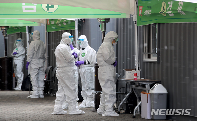 [서울=뉴시스] 조수정 기자 = 4일 오후 서울 송파구 잠실 주경기장에 설치된 '드라이브 스루(Drive Through) 신종 코로나바이러스 감염증(코로나19) 선별진료소'에서 방호복을 입은 의료진이 흩날리는 눈발을 맞고 있다. 서울시는 강서구 이대서울병원, 서초구 옛 소방학교, 은평구 은평병원, 잠실주경기장 주차장에서 드라이브 스루 선별진료소를 운영한다. 2020.03.04.&nbsp; chocrystal@newsis.com