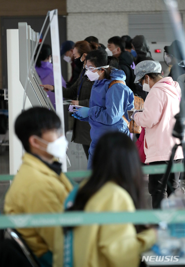 [인천공항=뉴시스]김선웅 기자 = 5일 인천국제공항에서 출국하는 외국인들이 코로나19 감염을 방지하기 위해 방호복, 마스크, 고글을 착용하고 있다. 2020.03.05.  mangusta@newsis.com