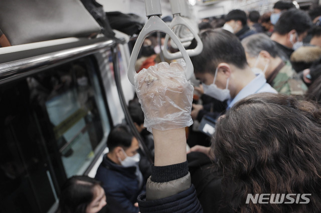 [서울=뉴시스] 박민석 기자 = 신종 코로나바이러스 감염증(코로나19) 확진자가 6000명을 넘어선 5일 오후 서울 지하철에서 한 승객이 일회용 위생 장갑을 착용하고 손잡이를 잡고 있다. 2020.03.05. mspark@newsis.com