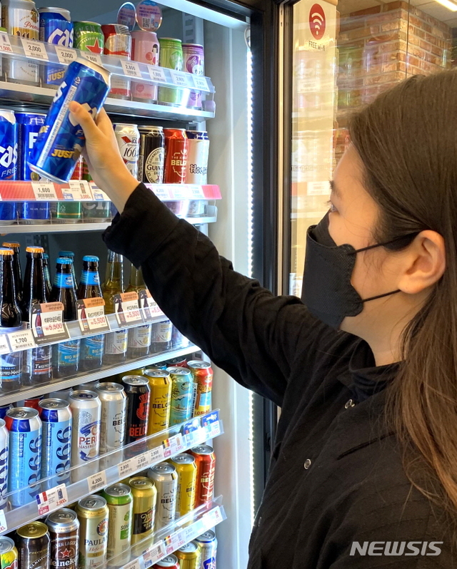 [서울=뉴시스] 고객이 이마트24 매장에서 행사 캔맥주를 고르고 있다. 이마트24는 홈술족 증가에 맞춰 맥주 캐시백 행사를 진행한다. 