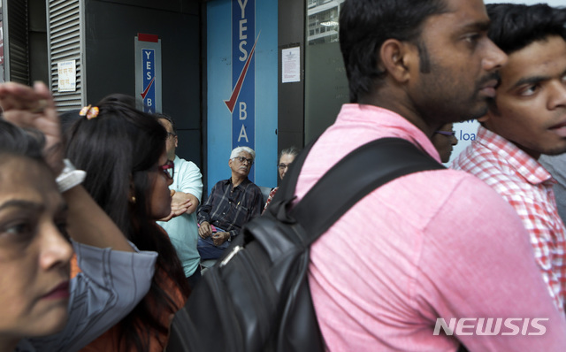 [뭄바이=AP/뉴시스] 22일(현지 시간) 파이낸셜타임스(FT)에 따르면 시장조사기관 딜로직은 올해 들어 외국 기업이 참여한 인도 금융 부문 거래 규모가 80억 달러로, 지난해 23억 달러, 2023년 14억 달러에서 크게 늘었다고 밝혔다. 사진은 인도 뭄바이의 예스뱅크 앞에 예금을 인출하려는 고객들이 줄 서 있는 모습. 2025.11.23.