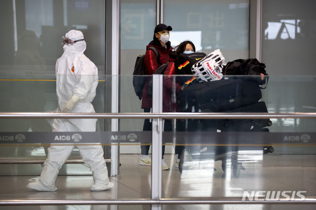 [베이징=AP/뉴시스]지난 3월6일 베이징 국제공항에서 보호복을 입은 공항 직원 1명이 외국에서 도착한 여행객들을 안내하고 있다. 2020.04.07