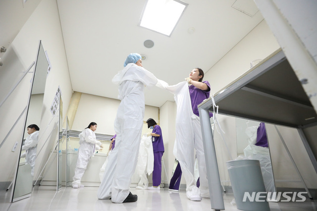 [서울=뉴시스]전신 기자 = 6일 신종 코로나바이러스 감염증(코로나19) 전담병원인 서울 중랑구 서울의료원에서 의료진이 병실로 향하기 전 방호복을 착용하고 있다. 2020.03.09. photo1006@newsis.com