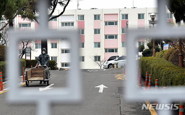 [대구=뉴시스] 이무열 기자 = 신종 코로나바이러스 감염증(코로나19) 확진자가 대거 발생한 7일 대구 달서구 한 아파트 출입구가 코호트 격리로 통제돼 있다. 닫힌 철문 사이로 보건당국 관계자가 자가격리자에게 택배 물건을 전달해주기 위해 분주히 움직이고 있다. 2020.03.07.&nbsp; lmy@newsis.com 