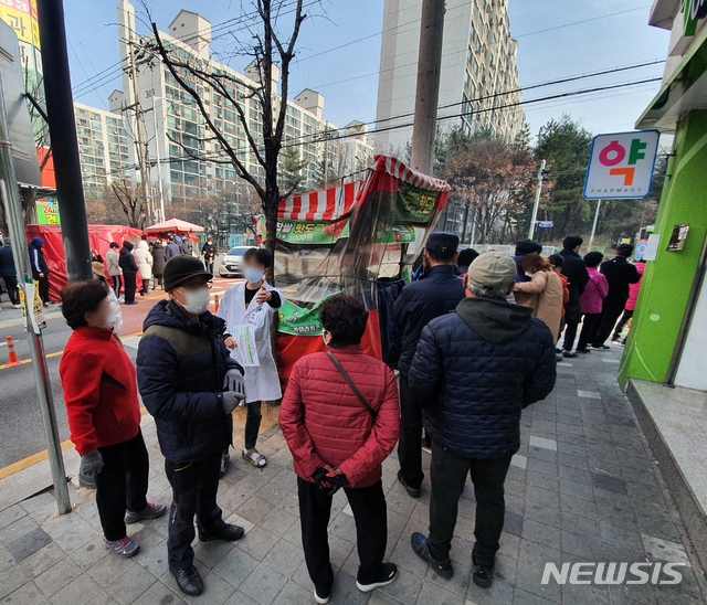 [청주=뉴시스] 조성현 기자= 마스크 5부제 시행 첫날인 9일 오전 9시께 충북 청주시 상당구 한 약국 앞 인도에서 마스크를 구매하기 위해 줄지어 서 있는 시민들에게 약사가 마스크 5부제에 대해 설명하고 있다. 2020.03.09. jsh0128@newsis.com