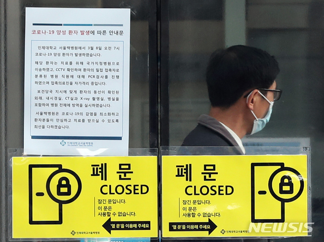 [서울=뉴시스]이윤청 기자 = 9일 오전 서울 중구 인제대학교 백병원에서 한 병원 관계자가 업무를 보고 있는 가운데 코로나19 양성 환자 발생 관련 안내문이 붙어 있다. 8일 서울백병원에 입원 중이던 41년생 여성 환자가 신종 코로나 바이러스 감염증(코로나19) 확진 판정을 받아 백병원 병동 일부와 응급실이 폐쇄됐다. 환자는 확진 판정을 받은 후에야 실 거주지가 대구라고 밝혔으며 이후 국가지정 격리병상으로 이송됐다. 2020.03.09.&nbsp; radiohead@newsis.com