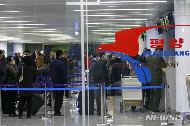 [평양=AP/뉴시스]지난해 3월9일 북한 평양의 평양 국제공항에서 마스크를 쓴 승객들이 러시아 블라디보스토크행 항공기 탑승 수속을 하고 있다. 코로나19 차단을 위해 국경을 봉쇄한 북한은 외국인 이송을 위해 특별 항공편을 마련했다. 2021.08.12.