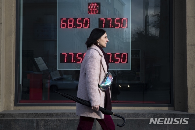 [모스크바=AP/뉴시스]러시아 모스크바에서 지난 9일 한 여성이 미 달러화와 유로화의 러시아 루블 간 환율이 표시된 환전소 전광판 앞을 지나가고 있다. 사우디아라비아와 러시아 간충돌로 유가가 폭락하는 가운데 사우디와 러시아 모두 증산 가능성을 언급해 유가 추가 하락 우려가 커지고 있다. 2020.3.11