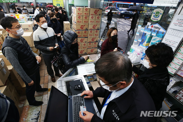 [서울=뉴시스] 이영환 기자 = 마스크 5부제 시행 이틀째인 10일 오전 서울 종로구의 한 약국에서 시민들이 신분증을 제시하며 마스크를 구매하고 있다. 2020.03.10.&nbsp;&nbsp; photo@newsis.com