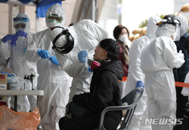 [서울=뉴시스] 박민석 기자 = 산업용 분진 마스크를 착용한 시민이 10일 오후 건물 콜센터 근무자가 신종 코로나바이러스 감염증(코로나19) 확진자로 확인돼 폐쇄된 서울 구로구 코리아빌딩에 설치된 선별진료소에서 검사를 받고 있다. 2020.03.10.&nbsp; mspark@newsis.com