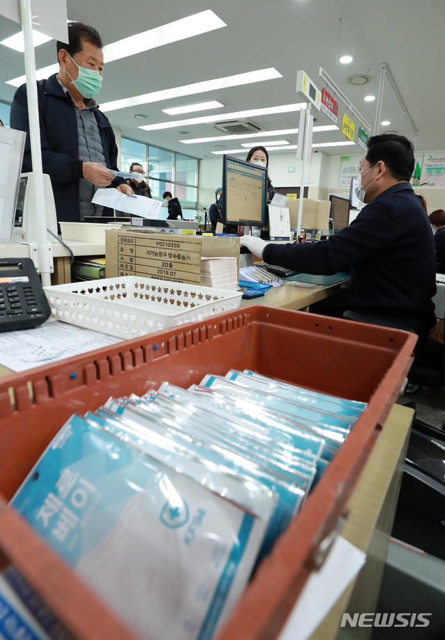 [남양주=뉴시스] 이영환 기자 = 시민들이 마스크 5부제 시행 사흘째인 11일 오전 경기 남양주시 진접읍 진접우체국에서 신분증을 제시하며 마스크를 구매하고 있다. 과학기술정보통신부 우정사업본부는 중복구매확인시스템 구축을 완료해 이날부터 1주 1인 2매 판매를 시행한다고 밝혔다. 2020.03.11.&nbsp; 20hwan@newsis.com