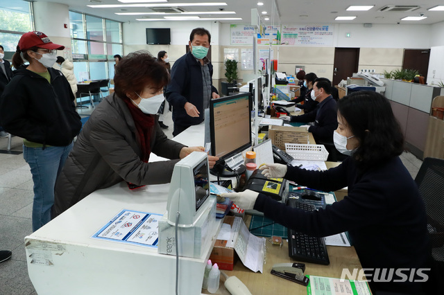 [남양주=뉴시스] 이영환 기자 = 시민들이 마스크 5부제 시행 사흘째인 11일 오전 경기 남양주 진접읍 진접우체국에서 신분증을 제시하며 마스크를 구매하고 있다. 과학기술정보통신부 우정사업본부는 중복구매확인시스템 구축을 완료해 이날부터 1주 1인 2매 판매를 시행한다고 밝혔다. 2020.03.11.&nbsp; 20hwan@newsis.com
