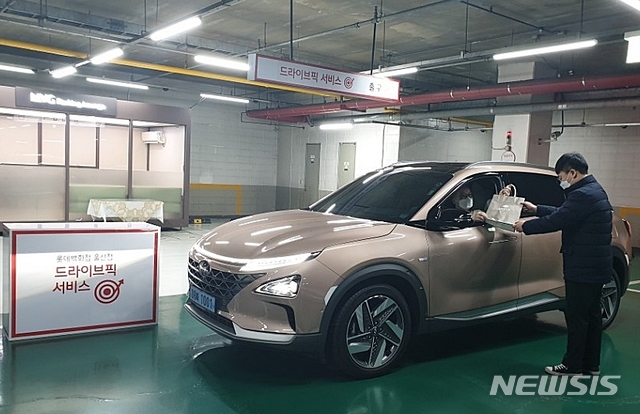 [울산=뉴시스] 박수지 기자 = 롯데백화점 울산점이 코로나19 확산 방지를 위해 '드라이브픽 서비스'를 도입한 가운데 손님이 백화점 주차장에서 상품을 수령하고 있다. 2020.03.12.(사진=롯데백화점 울산점 제공)&nbsp; photo@newsis.com