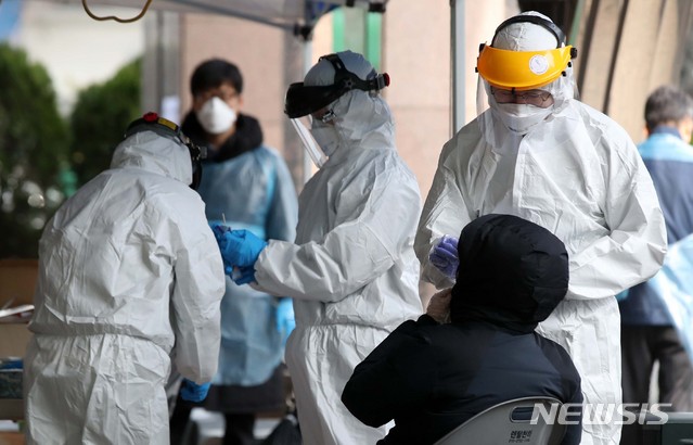 [서울=뉴시스]김선웅 기자 = 12일 코로나19 집단 감염 발생 콜센터가 위치한 서울 구로구 코리아빌딩 앞에 설치된 선별진료소에서 의료진이 의심환자 검체를 채취하고 있다. 한편 세계보건기구(WHO)는 코로나19의 팬데믹(세계적 대유행)을 선언했다. 2020.03.12.&nbsp; mangusta@newsis.com