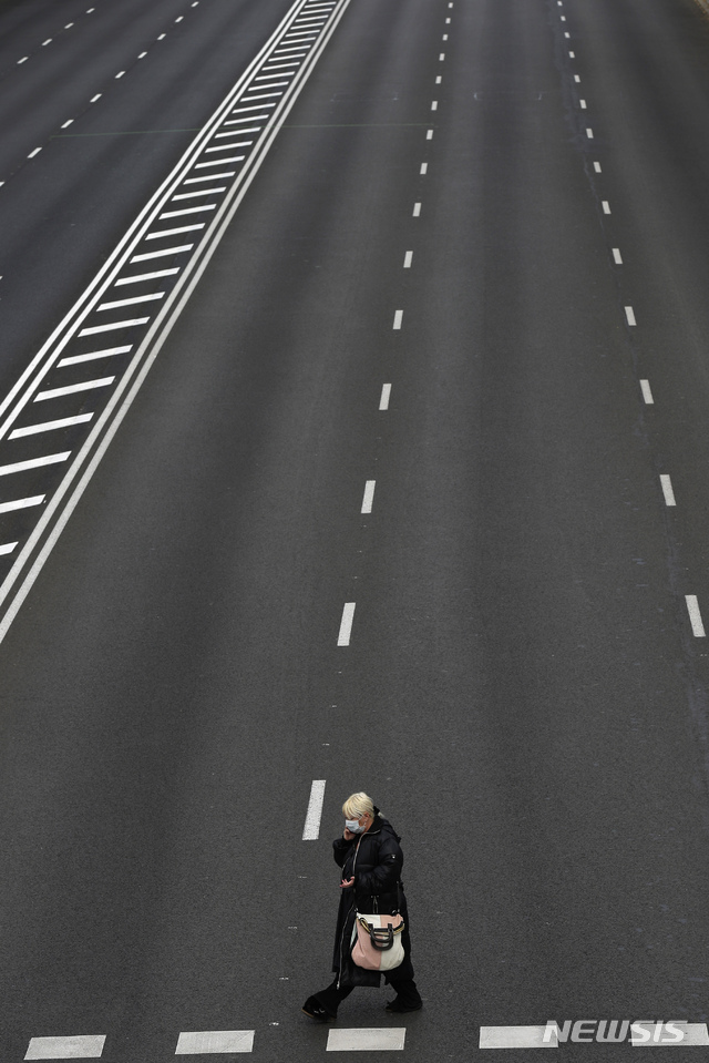 [마드리드=AP/뉴시스] 12일 스페인 수도의 도심 거리가 텅 빈 가운데 마스크 쓴 한 여성이 혼자 걸어가고 있다. 마드리드의 모든 학교는 23일까지 휴교 조치되었다. 2020. 3. 12.&nbsp; 