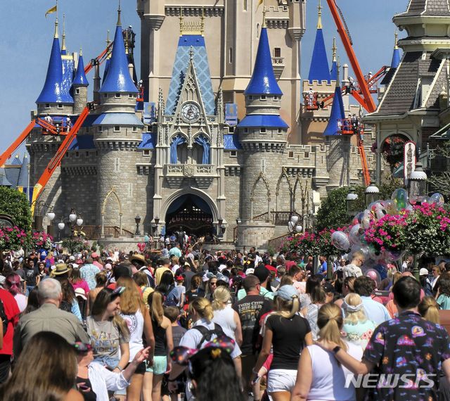 [레이크부에나비스타=AP/뉴시스]지난 3월12일( 미 플로리다주 레이크 부에나 비스타의 월트디즈니월드 신데렐라 궁전 앞 메인 스트리트에 관광객들이 몰려들고 있다. 월트디즈니월드는 신종 코로나바이러스 감염증 여파로 3월말까지 테마파크를 폐쇄한다고 발표했고 아직 완전한 업무 복귀는 이뤄지지 않았다. 